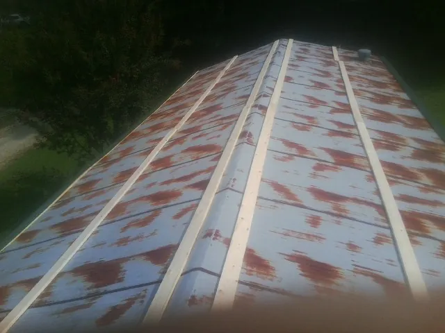 Rusted metal roof panels with new wood purlins before replacement — Storm Damage Roof Repair in Whitmore Lake by Roofing Brothers