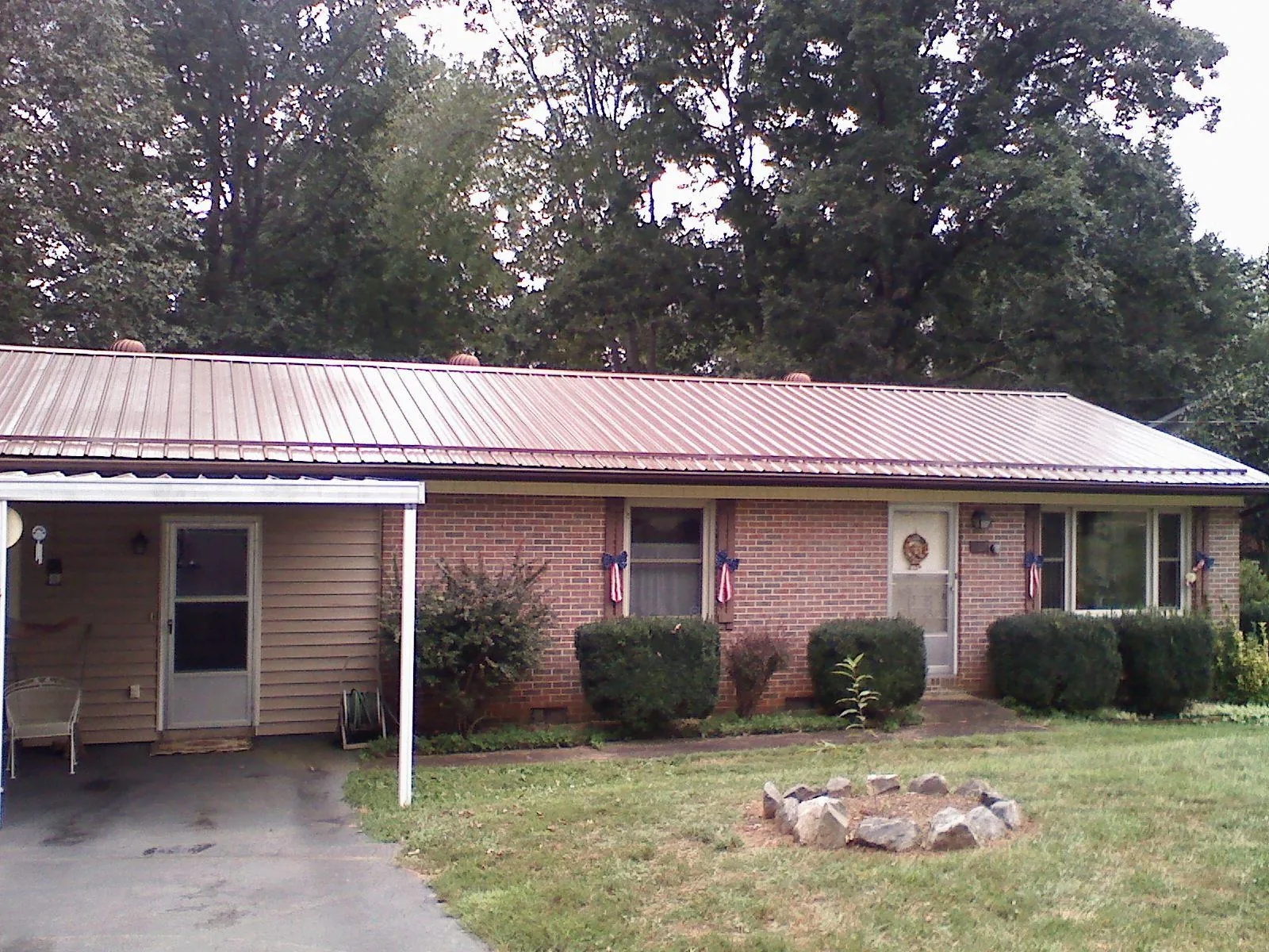 Bronze metal roof and carport on a brick ranch home — Roof Repair work by our crew in Whitmore Lake