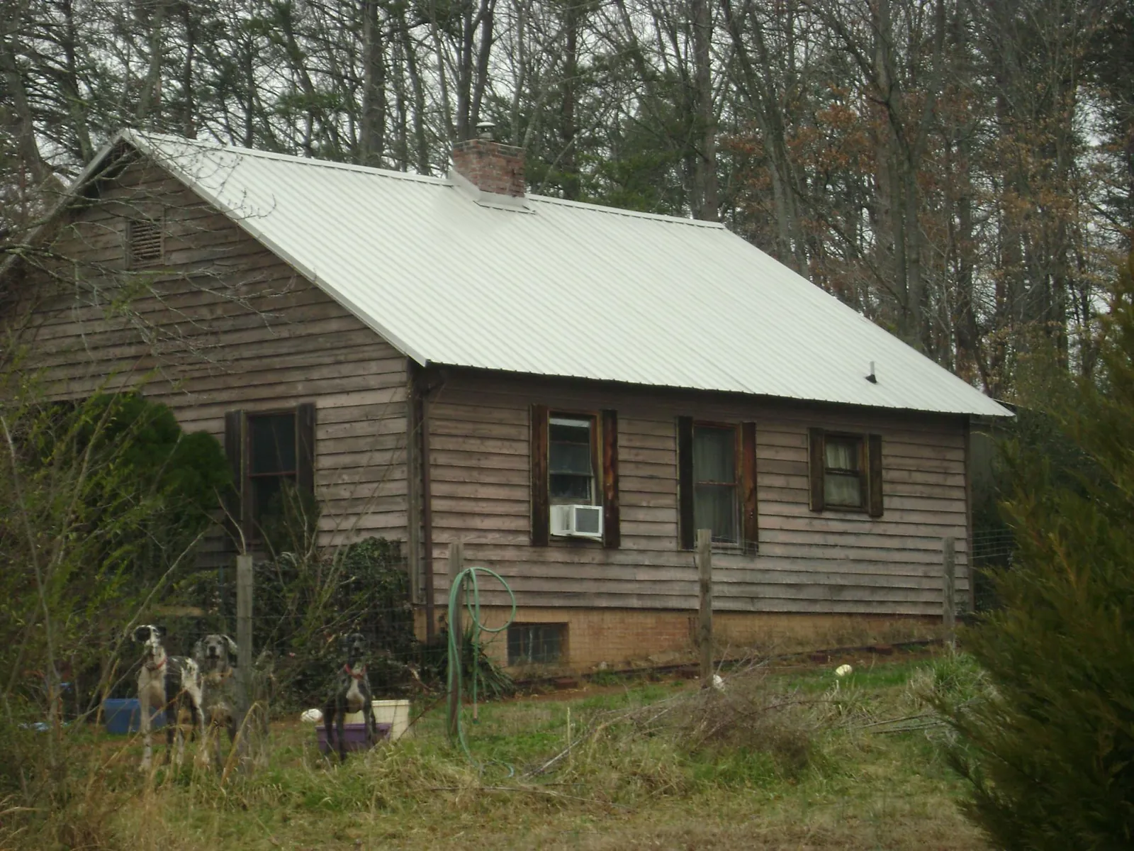 White metal roof on an old wood sided farmhouse, from a Metal Roof Installation job in Whitmore Lake